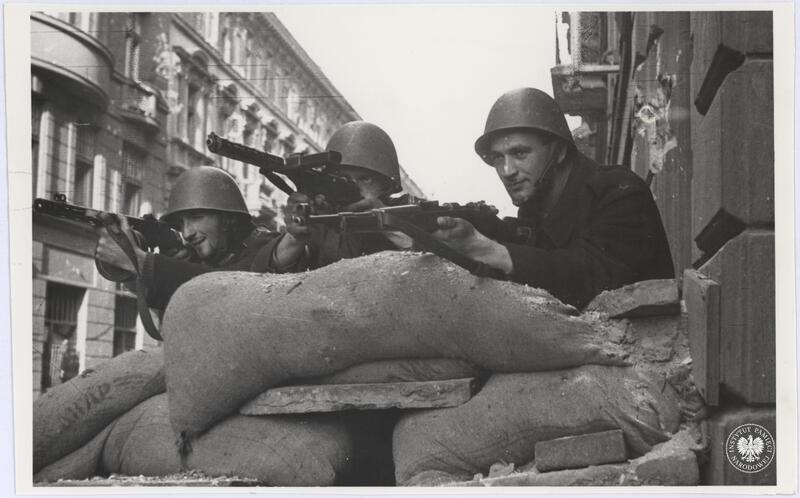 Trzech niezidentyfikowanych powstańców z nieustalonego oddziału AK stoi na jednej z ulic w Śródmieściu Północnym, fot. Henryk Śmigacz, z zasobu Archiwum IPN, sygn. IPNBU-2-21-28-3-1