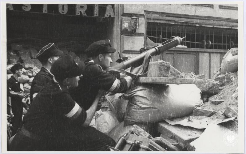 Kilku niezidentyfikowanych powstańców z nieustalonego oddziału AK na barykadzie na ul. Chmielnej między Hotelem Astoria a narożną kamienicą, fot. H. Śmigacz, z zasobu Aruchiwum IPN, sygn. IPNBU-2-21-26-4-1