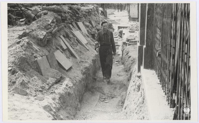 Niezidentyfikowany powstaniec idzie wykopanym przejściem na jednej z ulic w Śródmieściu Północnym, fot. Henryk Śmigacz, z zasobu Archiwum IPN, IPNBU-2-21-29-1-1